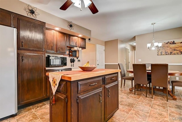 kitchen with dark brown cabinets, white refrigerator, decorative light fixtures, a center island, and butcher block countertops