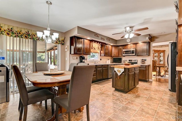 dining area with sink and ceiling fan with notable chandelier