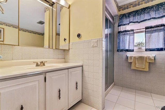 bathroom with vanity, a shower, tile patterned floors, and tile walls