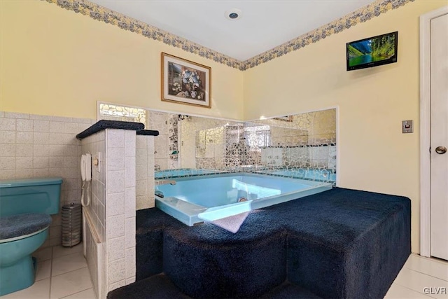 bathroom featuring toilet, tile patterned floors, a bathing tub, and tile walls