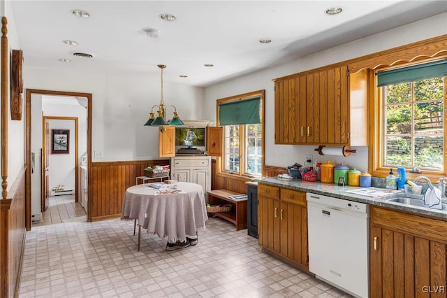 kitchen featuring decorative light fixtures, a healthy amount of sunlight, sink, and white dishwasher