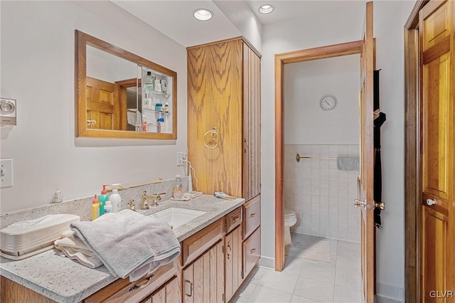 bathroom featuring vanity, toilet, tile walls, and tile patterned flooring