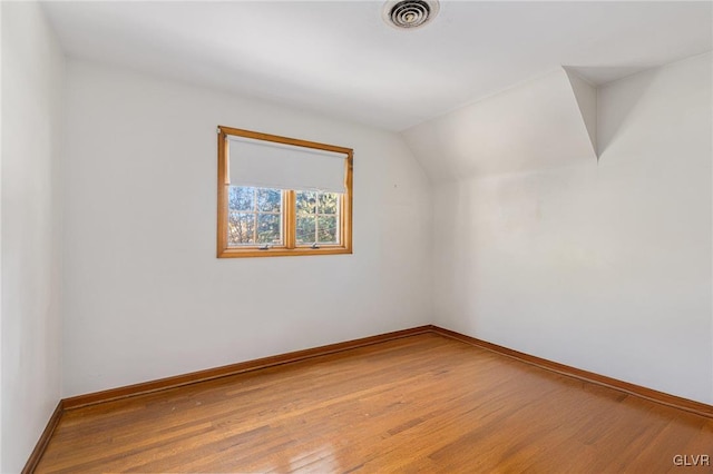 bonus room with wood-type flooring and vaulted ceiling