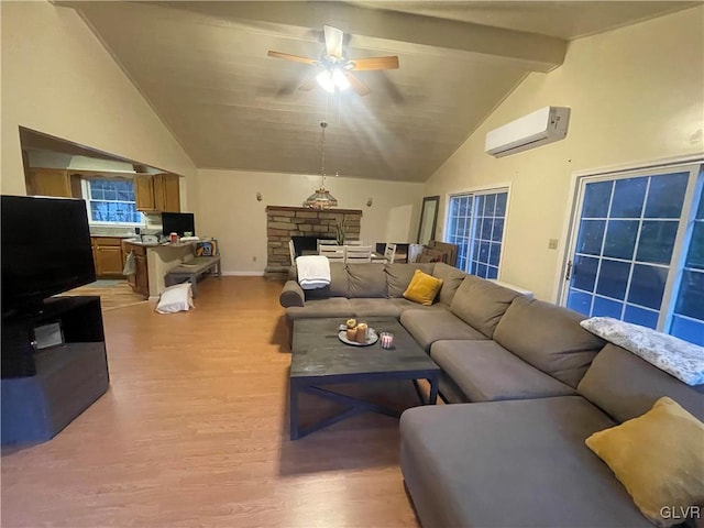 living room with light wood-type flooring, a wall mounted air conditioner, a stone fireplace, ceiling fan, and beam ceiling