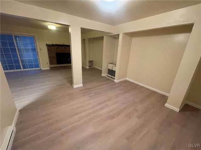 basement featuring light hardwood / wood-style floors and a fireplace