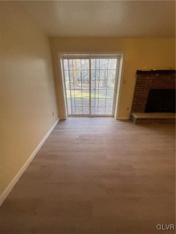 unfurnished living room with wood-type flooring and a fireplace