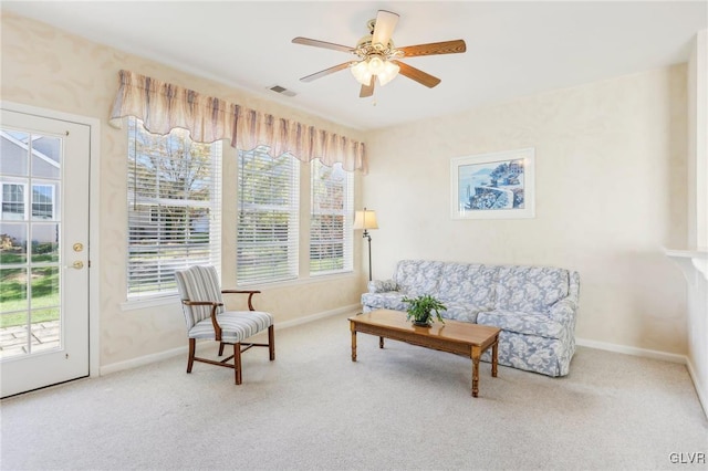 living area featuring ceiling fan and carpet