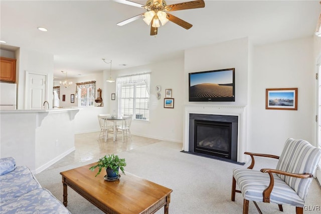 carpeted living room with ceiling fan and sink