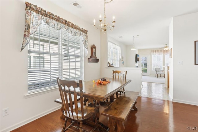 dining room with ceiling fan with notable chandelier and wood-type flooring