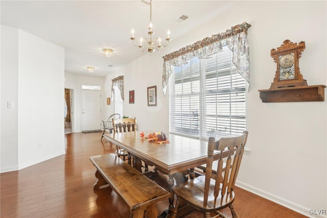 dining space featuring dark hardwood / wood-style flooring and a notable chandelier