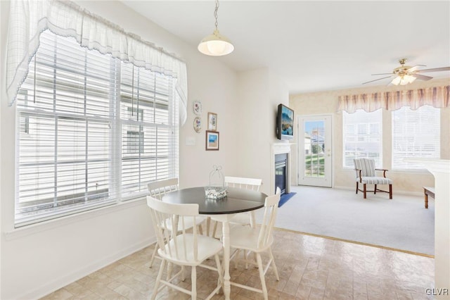 dining room with ceiling fan and light carpet