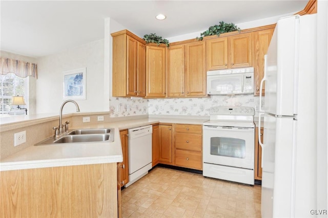 kitchen with decorative backsplash, sink, white appliances, and kitchen peninsula