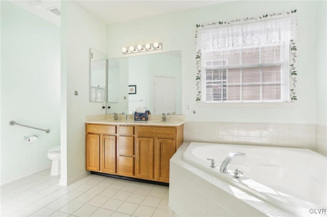 bathroom with toilet, tile patterned flooring, tiled tub, and vanity