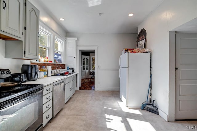 kitchen with black range with electric stovetop, dishwasher, sink, and white refrigerator