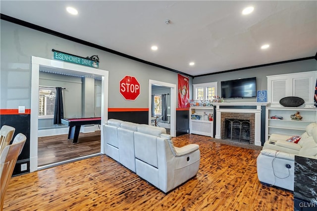 living room with pool table, hardwood / wood-style floors, a fireplace, and ornamental molding