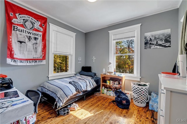 bedroom featuring ornamental molding and wood-type flooring