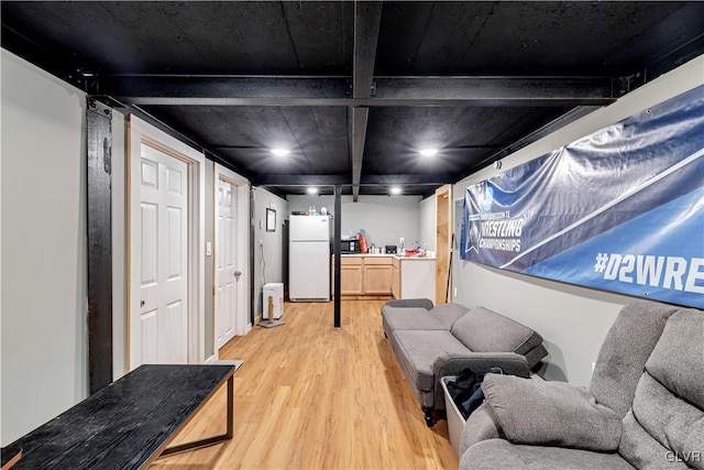 living area with light hardwood / wood-style floors and beam ceiling