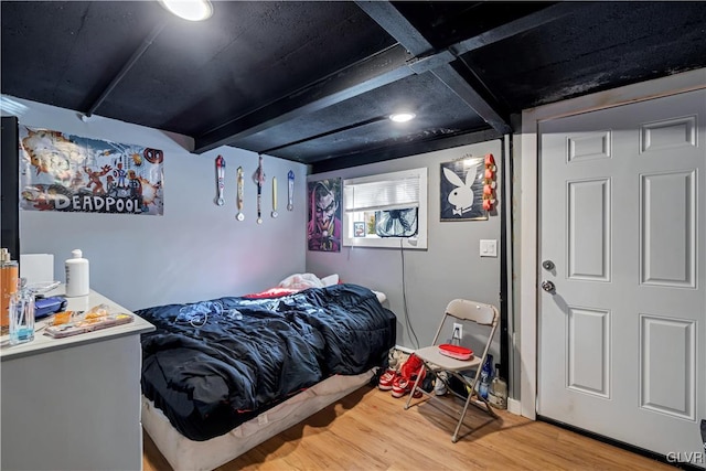 bedroom featuring beamed ceiling and wood-type flooring