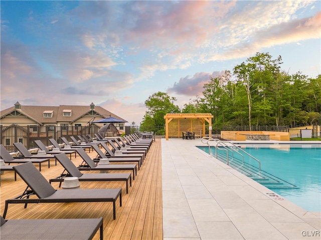 pool at dusk featuring a patio