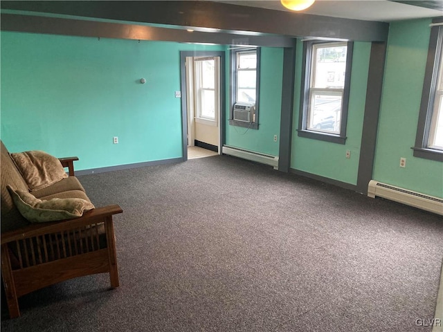 carpeted spare room featuring cooling unit, a healthy amount of sunlight, and baseboard heating