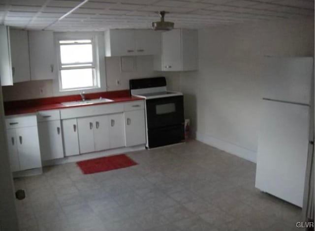 kitchen featuring white electric range oven, sink, and white cabinets