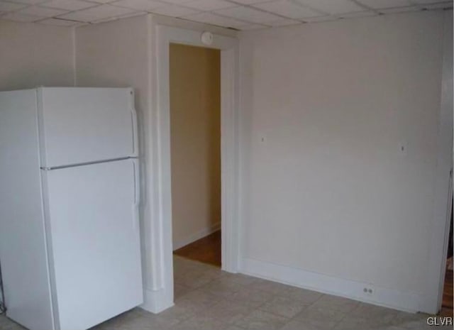 kitchen featuring white fridge and a paneled ceiling