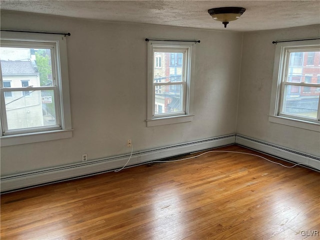 unfurnished room featuring a textured ceiling, plenty of natural light, and light wood-type flooring