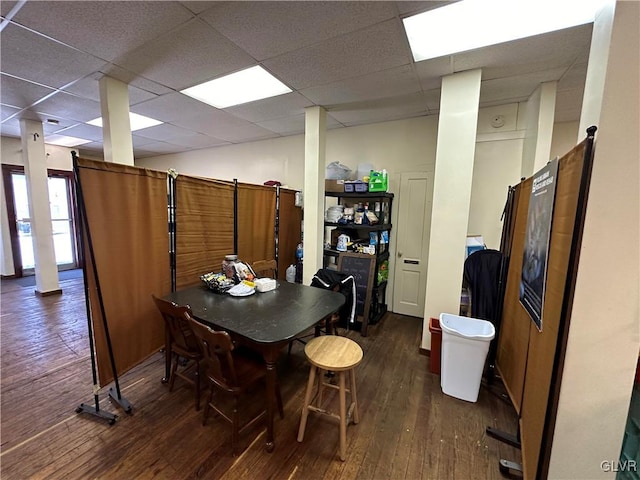 dining area featuring dark hardwood / wood-style flooring and a drop ceiling