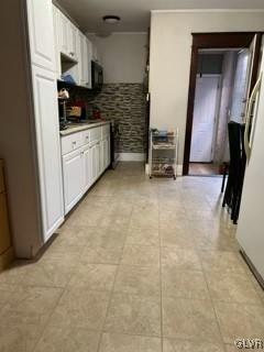 kitchen with white cabinets, white fridge, and light tile patterned floors