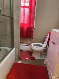 full bathroom with toilet, enclosed tub / shower combo, vanity, and a baseboard radiator