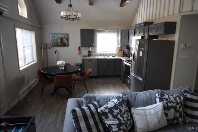 kitchen with gray cabinetry, appliances with stainless steel finishes, baseboard heating, and hardwood / wood-style floors