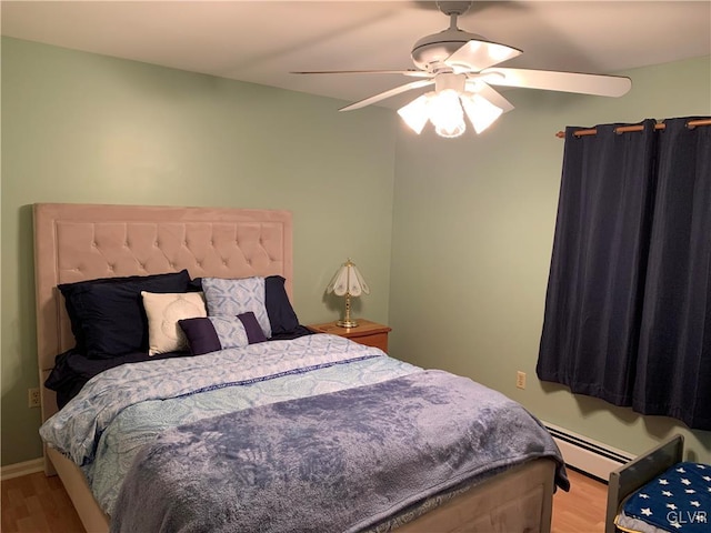 bedroom featuring light hardwood / wood-style flooring, a baseboard radiator, and ceiling fan