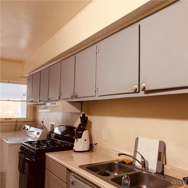 kitchen featuring washing machine and dryer, sink, and gray cabinets