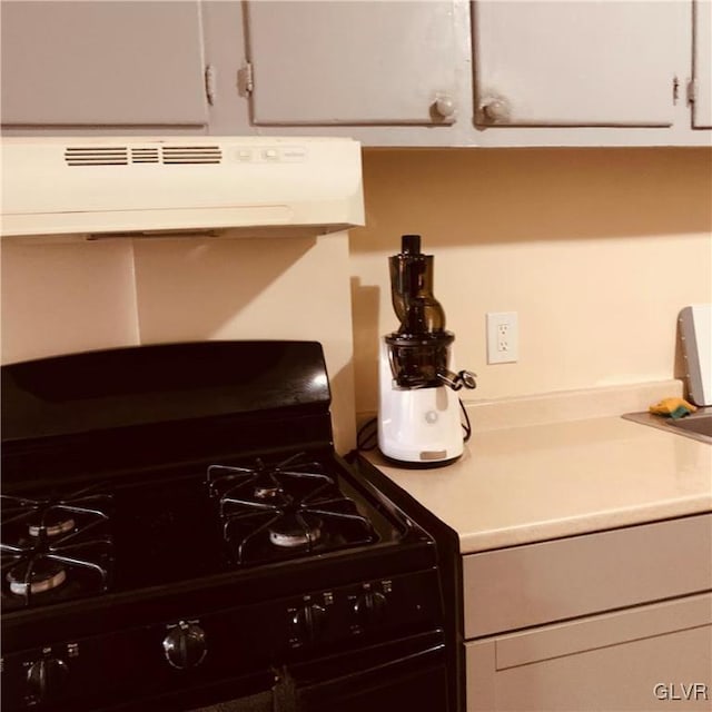 kitchen with gas stove, ventilation hood, and white cabinets