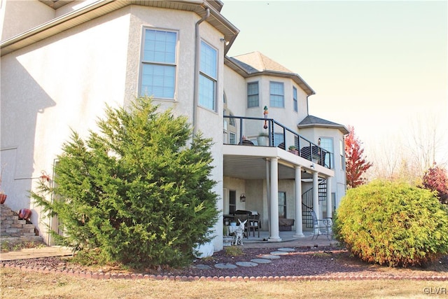 rear view of house featuring a patio area and a balcony