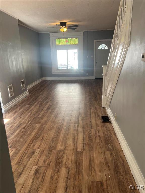 interior space with ceiling fan and dark hardwood / wood-style flooring