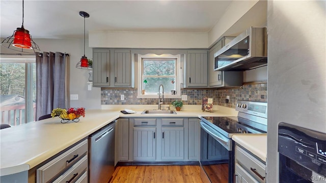 kitchen with a healthy amount of sunlight, stainless steel appliances, sink, and pendant lighting