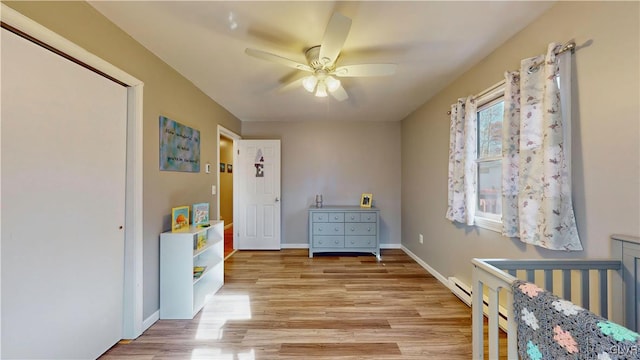 bedroom featuring a closet, a crib, light hardwood / wood-style floors, and ceiling fan