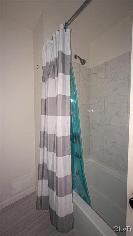 bathroom featuring hardwood / wood-style flooring and shower / tub combo