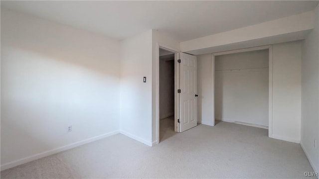 unfurnished bedroom with light carpet and a closet