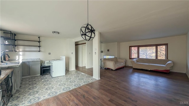 clothes washing area with sink, a barn door, and hardwood / wood-style flooring