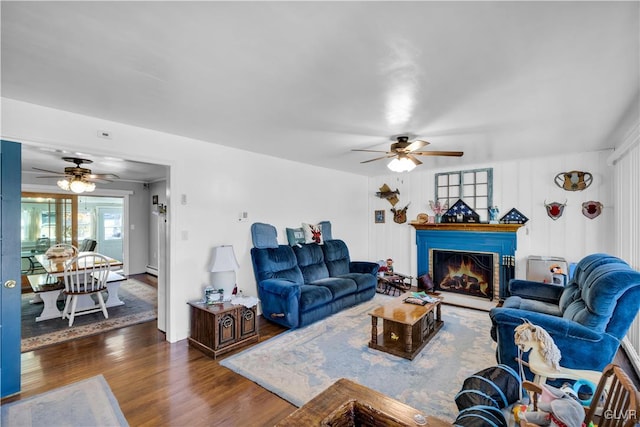 living room featuring dark wood-type flooring and ceiling fan