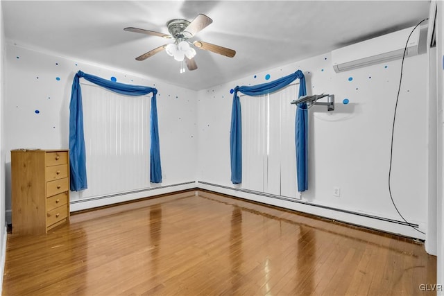 empty room with a baseboard radiator, a wall unit AC, wood-type flooring, and ceiling fan