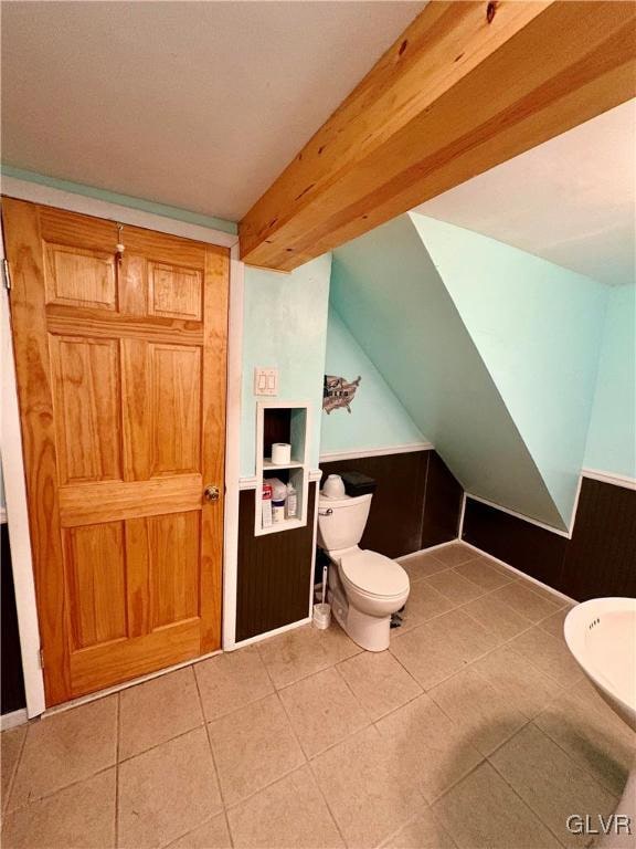 bathroom featuring tile patterned floors, toilet, and wooden walls