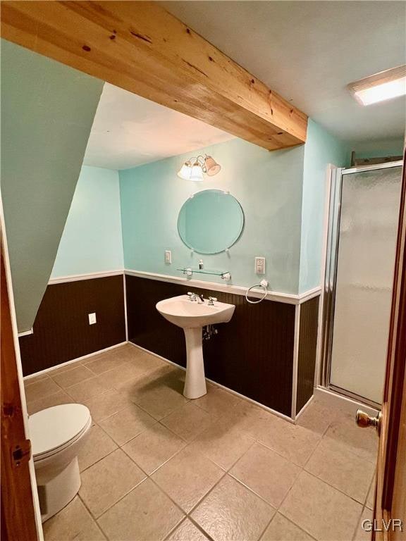 bathroom with tile patterned flooring, walk in shower, and beamed ceiling