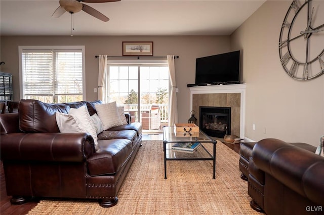 living room with ceiling fan, light hardwood / wood-style floors, and a fireplace