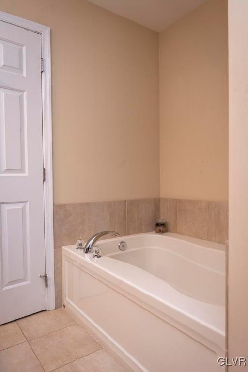 bathroom with tile patterned flooring and a washtub