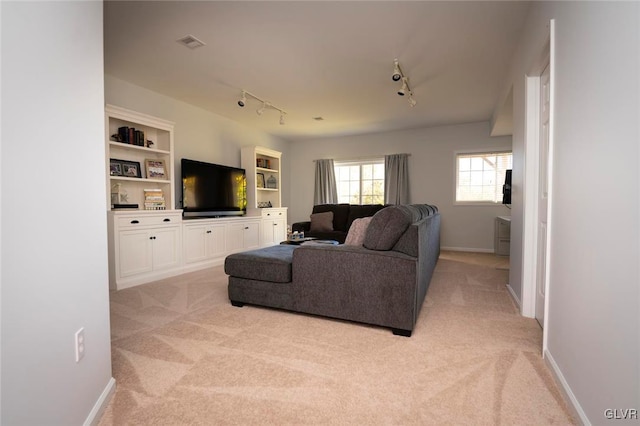 carpeted living room featuring track lighting