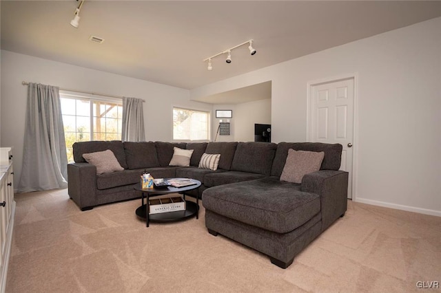 carpeted living room with track lighting