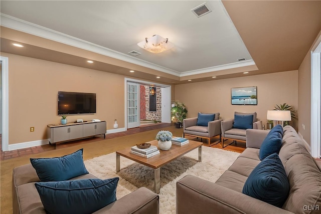 living room with crown molding and a tray ceiling